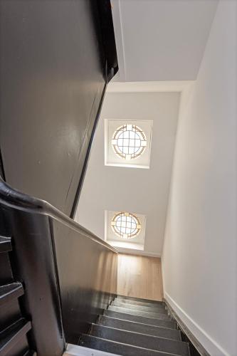 a staircase with two windows in a building at Märch - Mechelen Goat 21 in Mechelen