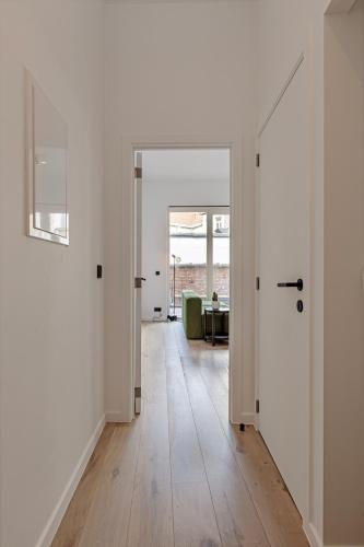 an empty hallway with white walls and wooden floors at Märch - Mechelen Goat 21 in Mechelen