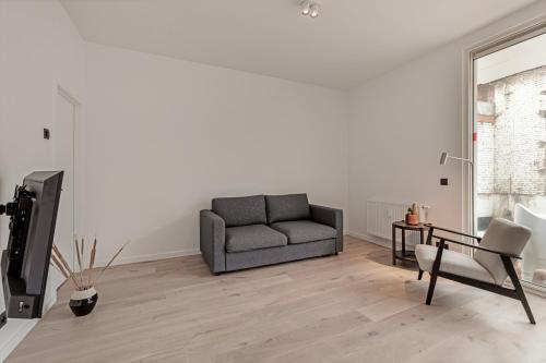 a living room with a couch and a chair at Märch - Mechelen Goat 21 in Mechelen