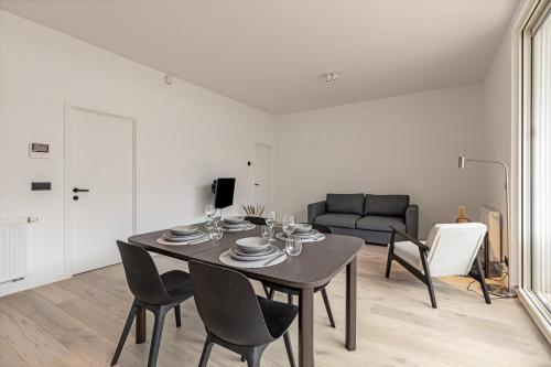 a dining room with a table and chairs and a couch at Märch - Mechelen Goat 21 in Mechelen