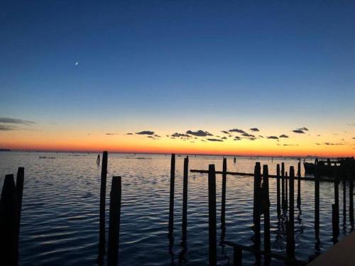 een zonsondergang boven een waterlichaam met een dok bij Ca’ MILLA in Venetië