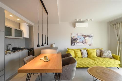 a kitchen and living room with a table and yellow couch at Kale Alti residences in Mirina