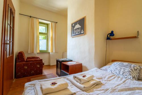 a bedroom with a bed and a chair and a window at Penzión Príjemný Oddych in Banská Štiavnica