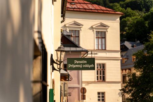 a street sign in front of a white building at Penzión Príjemný Oddych in Banská Štiavnica