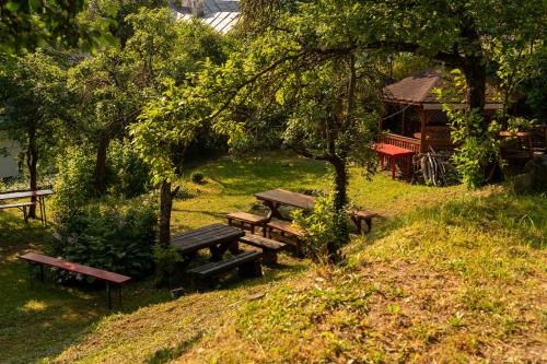 a group of picnic tables and a cabin in a park at Penzión Príjemný Oddych in Banská Štiavnica