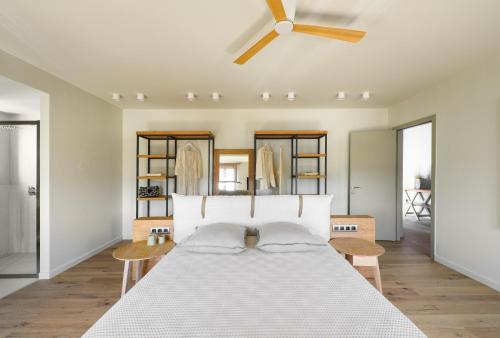 a bedroom with a bed with a ceiling fan at Kale Alti residences in Myrina