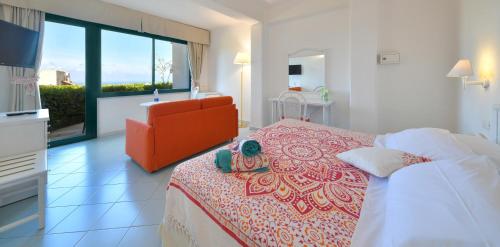 una camera con letto e sedia arancione di Paradiso Terme Resort & SPA con 5 piscine termali a Ischia