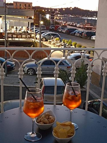 two wine glasses sitting on a table on a balcony at Le Dune Luxury Rooms in Vieste