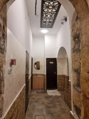 a hallway in a building with a black door at Palm Hostel in Jerusalem