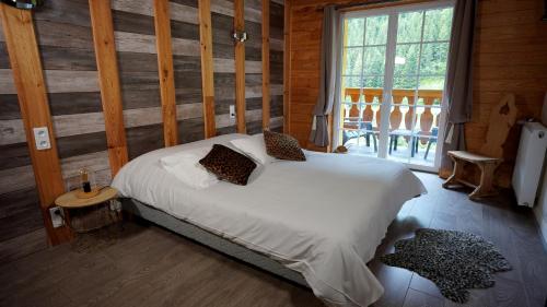 a bedroom with a bed in a room with wooden walls at La Sapinière St Lary Soulan in Saint-Lary-Soulan
