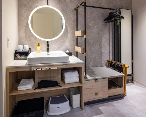 W łazience znajduje się umywalka i lustro. w obiekcie Hotel Kintetsu Universal City w Osace