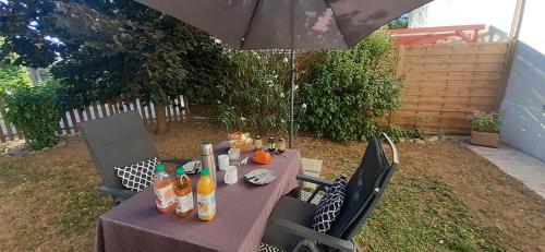 a table with bottles of drinks on it under an umbrella at Dacamaloya in Volx
