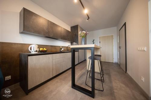 a kitchen with brown cabinets and a bar in it at Apartament 33 in Łańcut