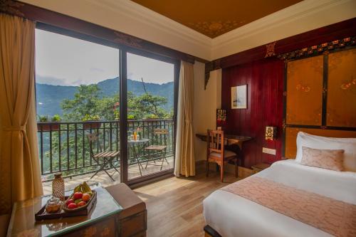 a bedroom with a bed and a balcony with a view at Amritara Hidden Land, Gangtok - 900 mts from MG Marg in Gangtok