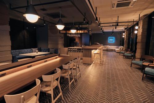 eine Bar in einem Restaurant mit Stühlen und einer Theke in der Unterkunft FAV LUX Hida Takayama in Takayama