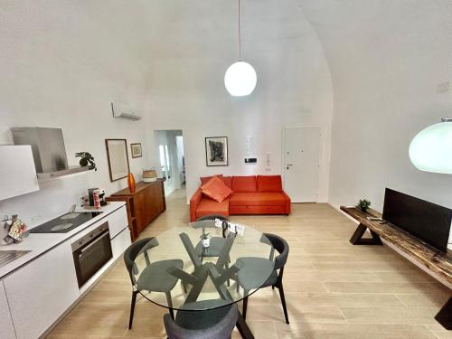 un soggiorno con un tavolo e un divano rosso di Volare House a Bari