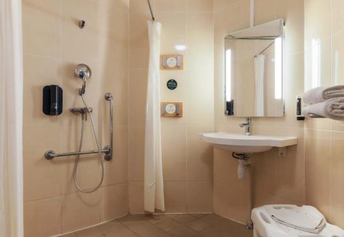 y baño con ducha y lavamanos. en B&B HOTEL Metz Jouy Aux Arches en Jouy-aux-Arches