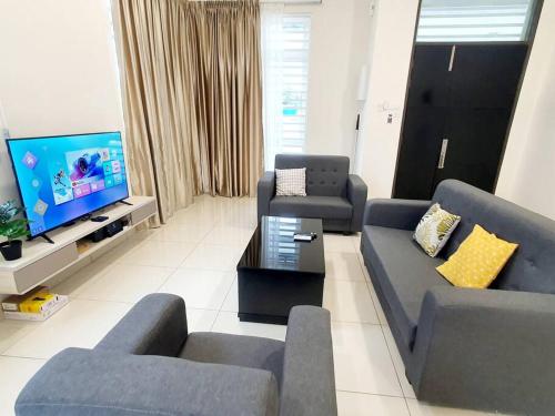 a living room with a couch and a tv at JOVIAL SingleStorey Bungalow 4Room10Pax `Alma in Bukit Mertajam