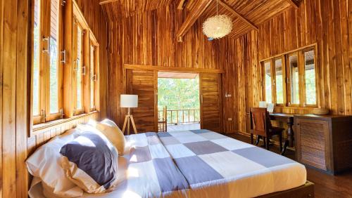 a bedroom with a bed and a desk in it at Baan Bhuwann Forest Chalet in Koh Phangan