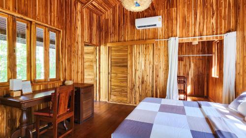 a bedroom with a desk and a bed in a room at Baan Bhuwann Forest Chalet in Koh Phangan