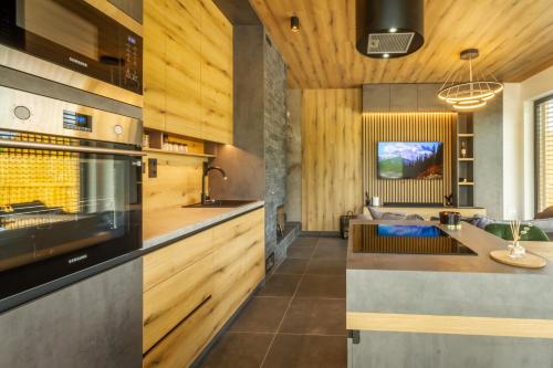 a kitchen with wood paneling and a stove top oven at Apartmány Černý Důl in Černý Dŭl