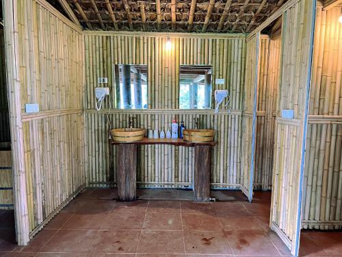 un bagno con due lavandini in una stanza con pareti di bambù di Lagom Su Phi Retreat a Hoàng Su Phì