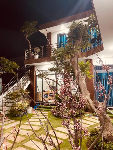 a house with a palm tree in front of it at Vila Ánh Dương in Cu Lao Thu