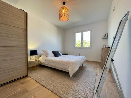 - une chambre avec un lit et une porte coulissante en verre dans l'établissement Villa La Paz ※ Climatisée, à Lézignan-Corbières