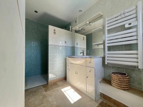 La salle de bains est pourvue d'un lavabo, d'une douche et d'un miroir. dans l'établissement Villa La Paz ※ Climatisée, à Lézignan-Corbières