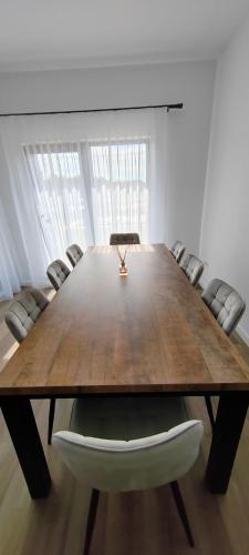 a conference room with a large wooden table and chairs at Casira Guesthouse in Sînmartin
