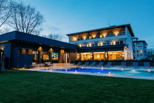 a large house with a swimming pool in front of it at Aqua Blu Hotel in Bad Füssing