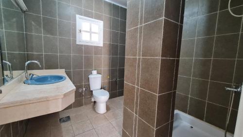a bathroom with a toilet and a sink and a shower at Zak Inn in Hurghada