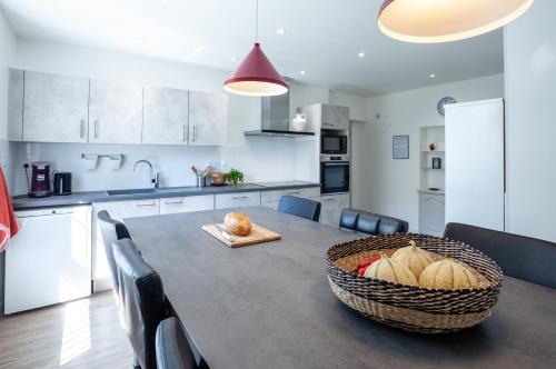 - une cuisine avec une table et un panier de pain dans l'établissement Appartement familial proche centre - Terrasse & Parking privé gratuit, à Avignon