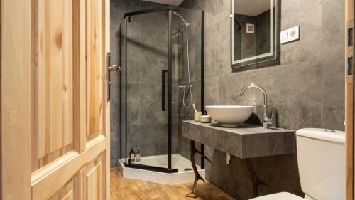 een badkamer met een wastafel en een glazen douche bij Dom Tatrzański Ewa in Kościelisko
