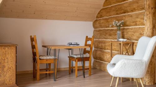 een tafel en stoelen in een kamer met een stenen muur bij Dom Tatrzański Ewa in Kościelisko