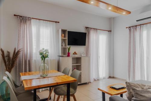 a dining room with a table and chairs and a television at Case d ' oro in Lefkímmi