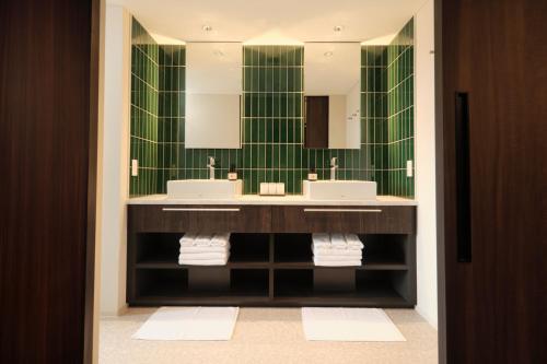 a bathroom with two sinks and a green wall at FAV LUX Hida Takayama in Takayama
