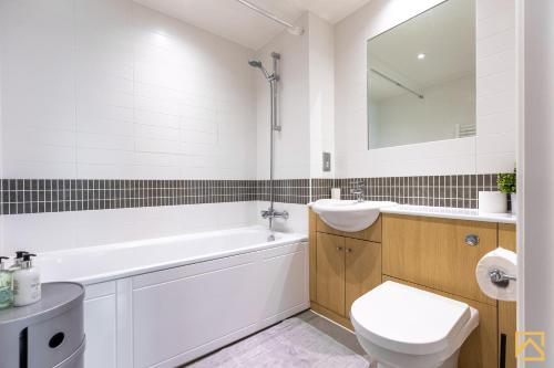a white bathroom with a sink and a toilet at Amazing view 2 bed, free parking By Valore Property Services in Milton Keynes