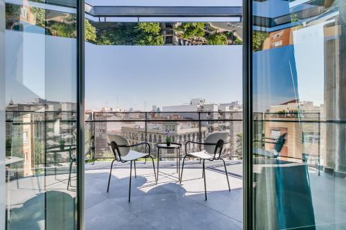 馬德里的住宿－Home Art Apartments Chamberí，阳台享有带桌椅的建筑景致。