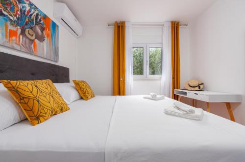 a bedroom with a large white bed and a window at Villa New Life Zadar in Sukošan