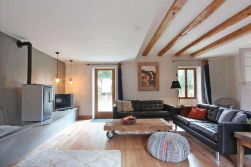 a living room with a couch and a table at L'ancienne Epicerie de POIL in Poil