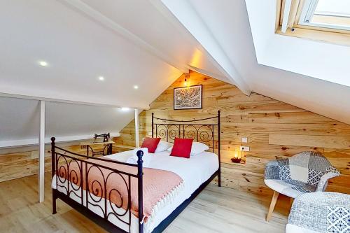 une chambre avec un lit dans une pièce aux murs en bois dans l'établissement L'Ingénieux - Appt près de la Place Zola, à Nantes