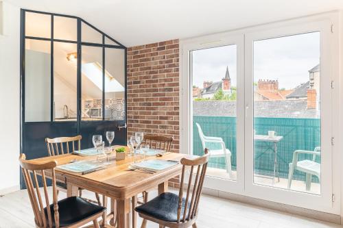 une salle à manger avec une table et des chaises en bois dans l'établissement L'Ingénieux - Appt près de la Place Zola, à Nantes