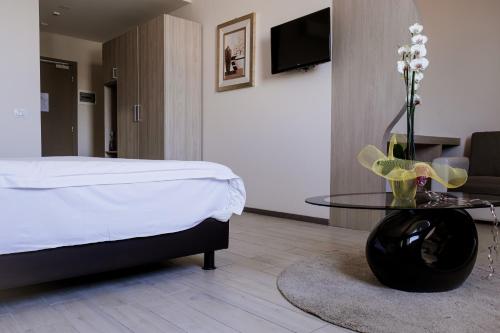Schlafzimmer mit einem Bett und einem Glastisch in der Unterkunft Queen Hotel in Sesto San Giovanni