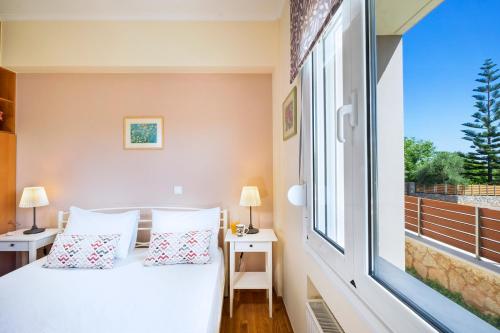 ein Schlafzimmer mit einem Bett und einem großen Fenster in der Unterkunft Vrahokipos Villa in Kounoupidiana