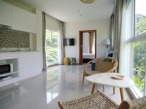 a living room with a table and some chairs at Karon beach apartment & sea view pool in Karon Beach