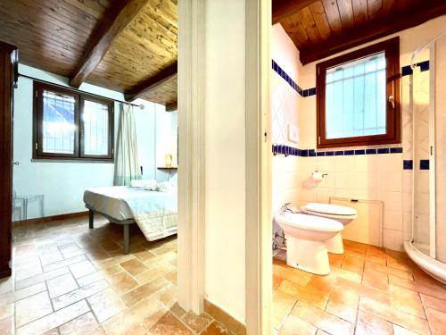 ein Bad mit einem WC, einem Waschbecken und einem Bett in der Unterkunft Le Corti Sarde On The Beach in Bari Sardo