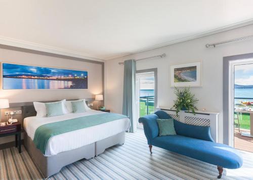 a bedroom with a bed and a blue chair at Sea Lodge Hotel in Waterville