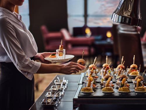 een vrouw met een bord eten op een tafel bij China World Summit Wing, Beijing in Beijing