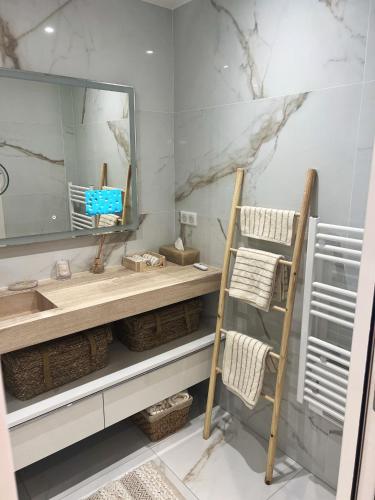 une salle de bain avec un lavabo et un miroir dans l'établissement Appartement confortable à Neuilly-sur-Seine 43 m² avec balcon, à Neuilly-sur-Seine